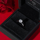 Round cut 4 claw solitaire moissanite engagement ring in 925 sterling silver displayed in black Adamans box with red rose background