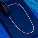 3mm rose gold tennis chain with prong-lifted diamond simulant stones on blue velvet background
