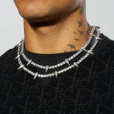 5mm Pave Spike Tennis Chain in White Gold on person wearing black sweater, showcasing prong-lifted stones.