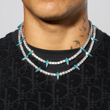 5mm blue pave spike tennis chain in white gold with blue enamel spikes on a person.