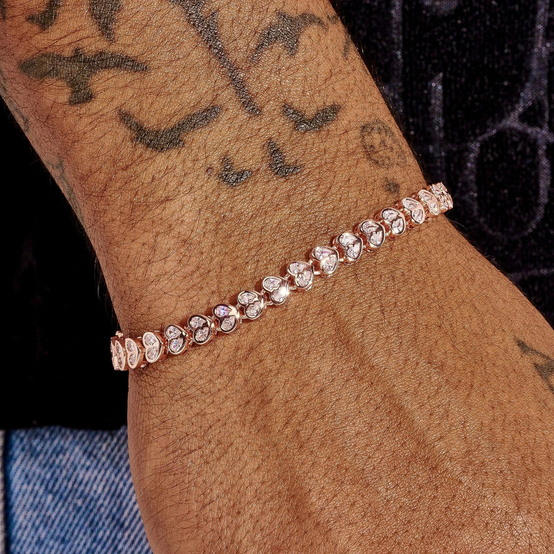 4mm moissanite broken heart bracelet in rose gold on wrist with tattoos and denim background