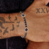 5MM black four leaf clover tennis bracelet in white gold worn on wrist with tattoo background