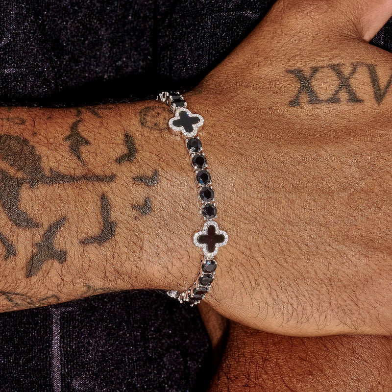 5MM black four leaf clover tennis bracelet in white gold worn on wrist with tattoo background