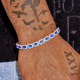 Sapphire cushion cut tennis bracelet in white gold with vivid blue stones on wrist