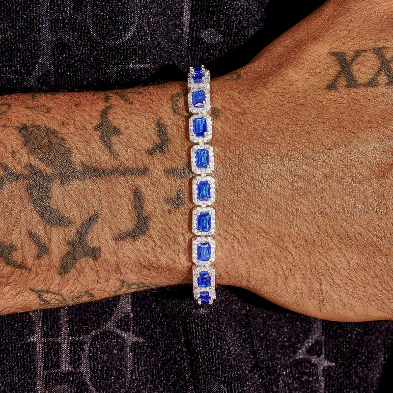 Men's wrist wearing sapphire cushion cut tennis bracelet in white gold with vivid blue sapphires