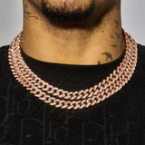 Close-up of a 13mm rose gold Cuban chain necklace with diamond simulants on a person's neck