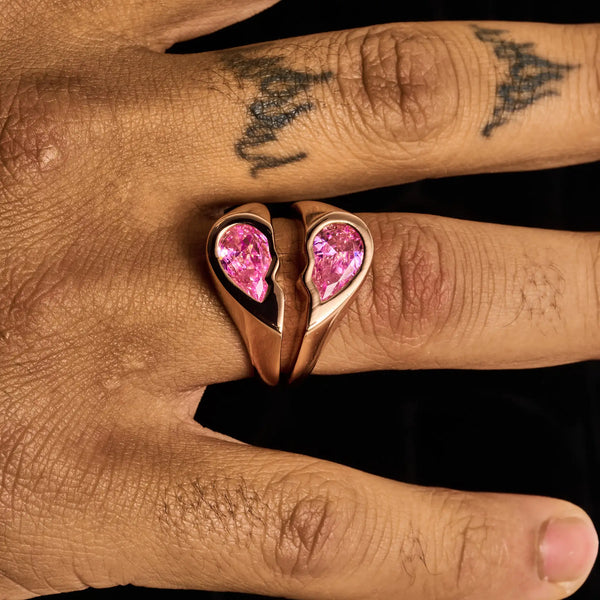 Rose gold broken heart ring with pink diamond simulants on finger