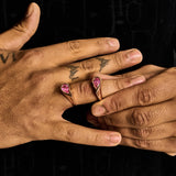 Rose gold broken heart ring with pink gemstones worn on hand, elegant bold jewelry design