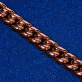Close-up of 10mm Cuban iced clasp chain in rose gold on blue background