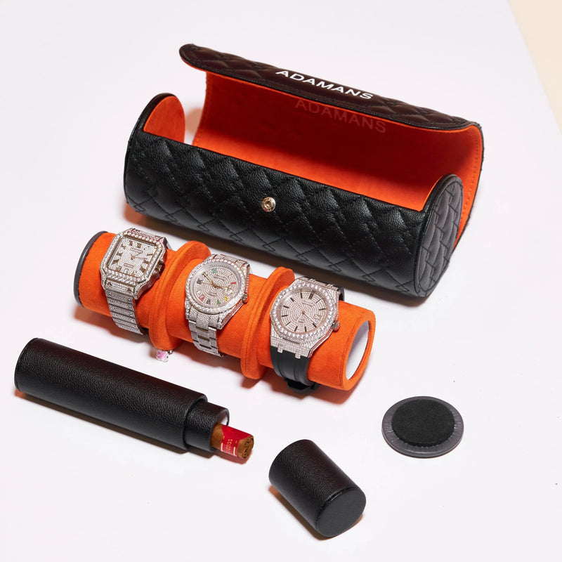 Black leather travel watch roll with orange interior and three luxury watches displayed