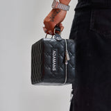 black leather travel jewellery case with quilted pattern and zipper held by hand