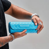Blue leather travel watch roll by Adamans held in hand with quilted design and adjustable strap