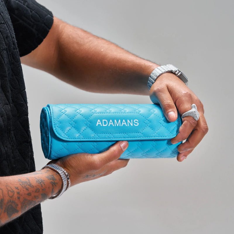 Blue leather travel watch roll by Adamans held in hand with quilted design and adjustable strap