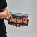Black premium leather travel watch roll by Adamans holding three watches with quilted exterior and orange interior lining