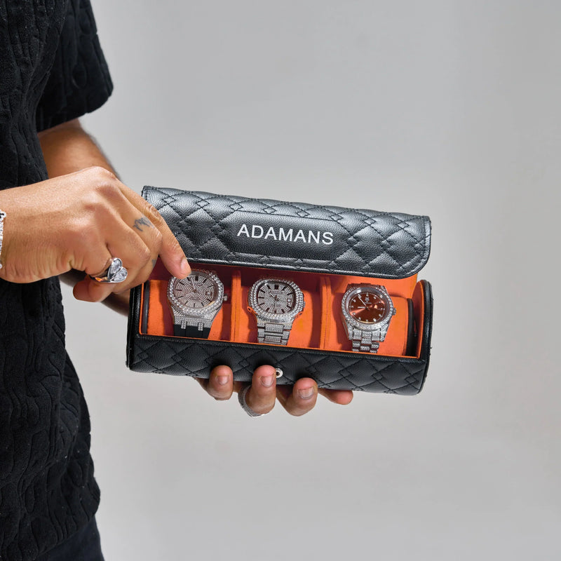 Black premium leather travel watch roll by Adamans holding three watches with quilted exterior and orange interior lining