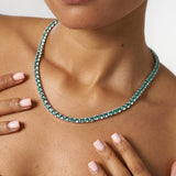 5mm green diamond tennis chain necklace in white gold worn on model's neck
