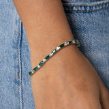 3mm green and white tennis bracelet in white gold on wrist against denim background