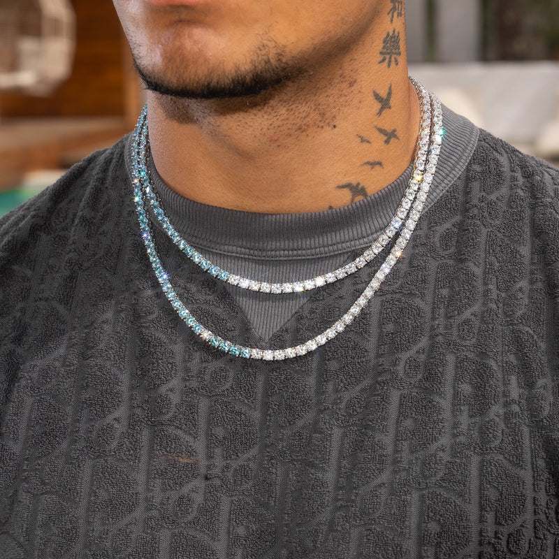 5mm pale blue and white tennis chain in white gold on man's neck with round cut prong-lifted stones.