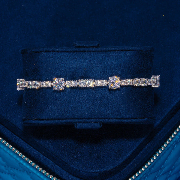 Gem Stationed Tennis Bracelet in white gold with sparkling CZ stones on navy velvet background