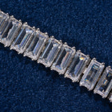 Close-up of 8MM Moissanite Baguette Tennis Bracelet with 925 silver setting on dark blue fabric background