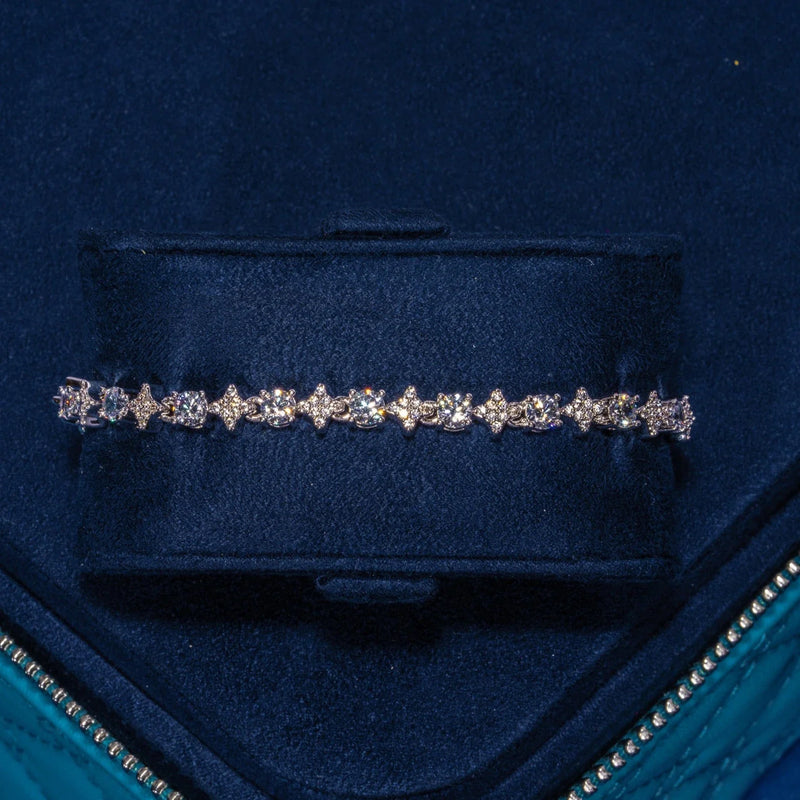 Round Stone Star Tennis Bracelet in white gold with round stones set in star motifs displayed in a blue velvet box