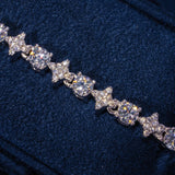 Round Stone Star Tennis Bracelet in white gold with sparkling round stones and star motifs on dark fabric background