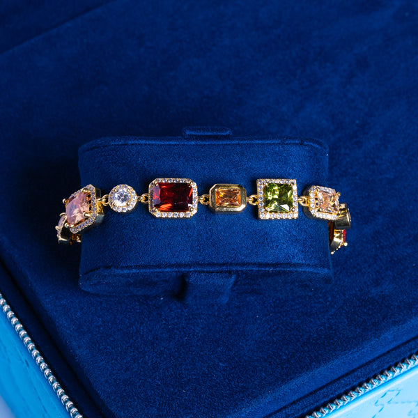10MM Moissanite multi gemstone bracelet in 18K vermeil with colorful rectangular and square stones on blue velvet background