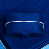 Micro Tennis Bracelet in white gold with 1.5mm round cut diamond simulants, elegant and sparkling on a blue velvet display.