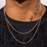Rose gold moissanite micro tennis chain on neck with black shirt and neck tattoos