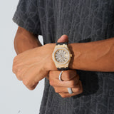 44mm paved VVS moissanite diamond watch with gold case and black silicone band on wrist