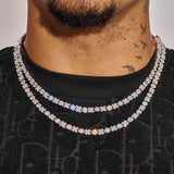 Close-up of a man wearing two white gold 5MM XOXO chains with diamond simulants and a black shirt.