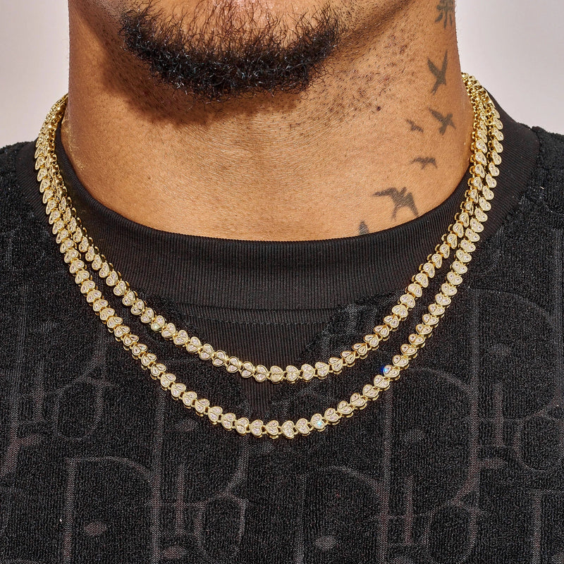 Gold Broken Heart Chain necklace on man with tattoos, layered fashion accessory