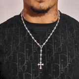 Flared Cross Rosary tennis chain necklace in white gold with radiant stones and bold cross pendant worn on neck