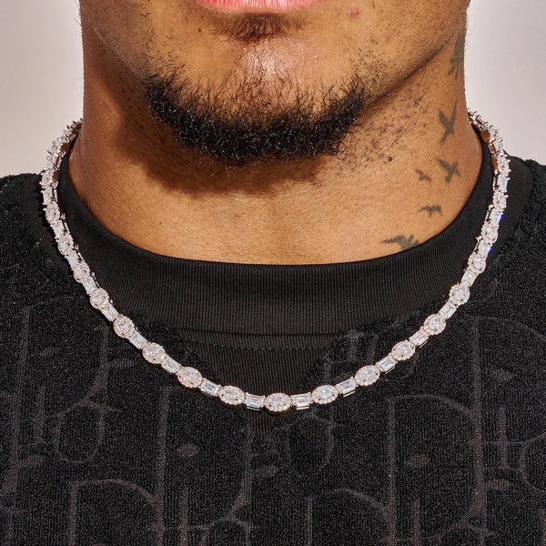 Close-up of 7MM moissanite oval emerald cut tennis chain in 925 silver with white gold plating worn on neck