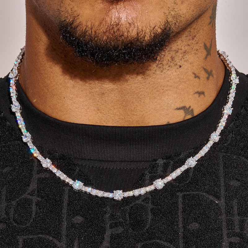 Close-up of Gem Stationed Tennis Chain in white gold with spaced gemstones worn on neck