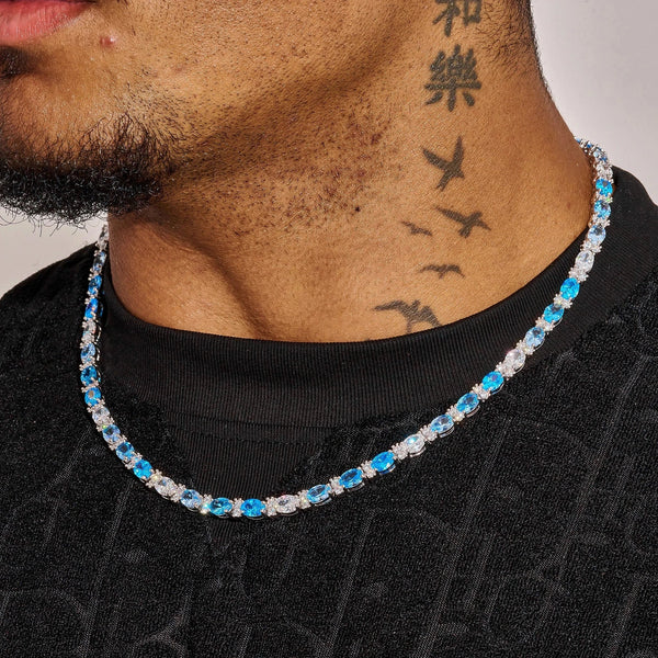 5MM Blue Ovals Tennis Chain in white gold with vibrant blue oval stones and diamond simulants worn on neck