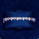 8MM opal and pear tennis bracelet in white gold with radiant stones on dark blue background