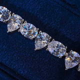 8MM Opal and Pear Tennis Bracelet in white gold with pear-cut cubic zirconia stones on dark blue background