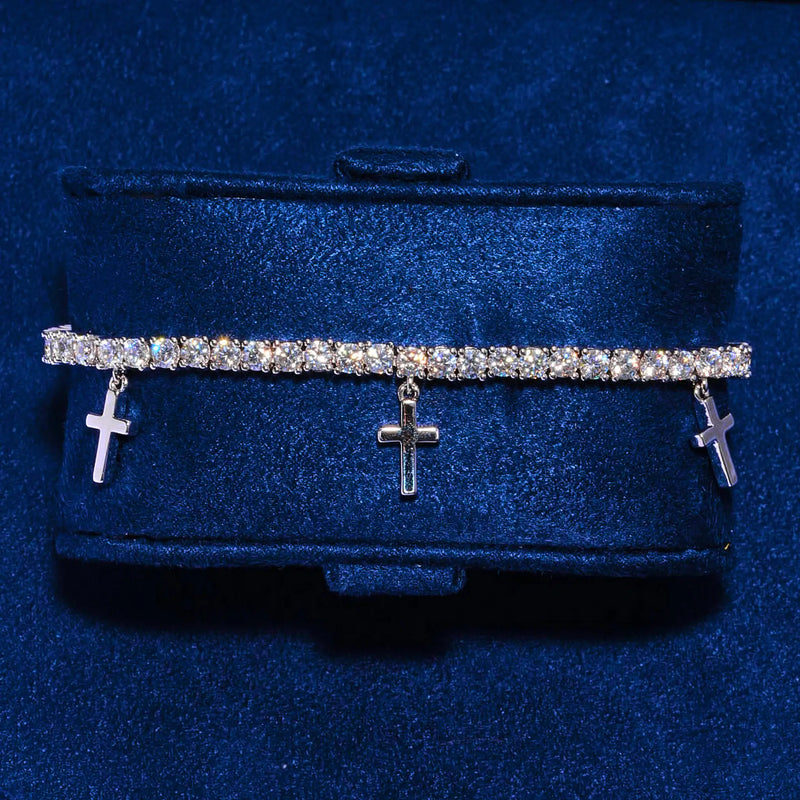 3MM tennis bracelet in white gold with five dangling silver crosses and CZ stones on blue background