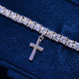 3MM tennis bracelet in white gold with dangling silver crosses and CZ stones on blue background
