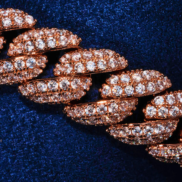 Close-up of 8mm moissanite iced Cuban link bracelet in rose gold with sparkling diamonds on dark blue background