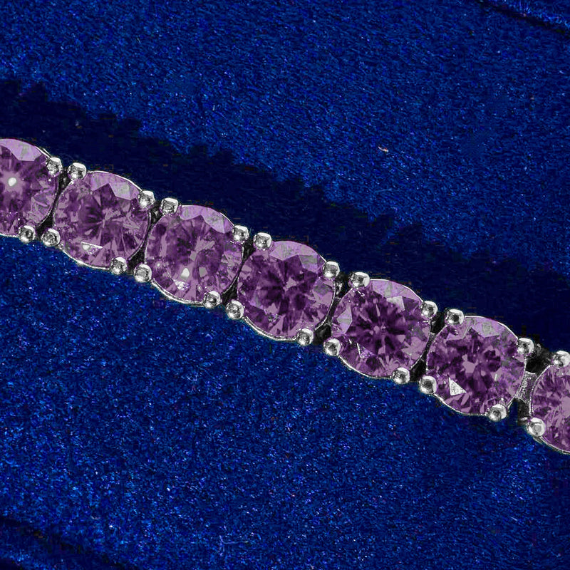 Close-up of 5mm tennis bracelet with purple amethyst stones set in silver prongs on blue background