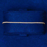 18K gold micro tennis bracelet with round cut diamond simulants in blue velvet box