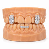 Two oversized oval cut moissanite stones set on the upper side teeth with a slim iced bar across the lower front teeth, front view