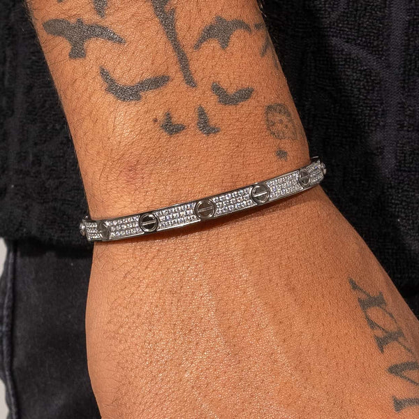 White gold iced band bracelet with diamond accents on wrist, Cartier inspired design
